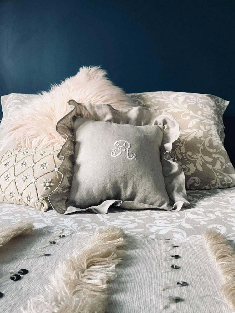 Coussin lin monogramme et broderie blanche, à volants