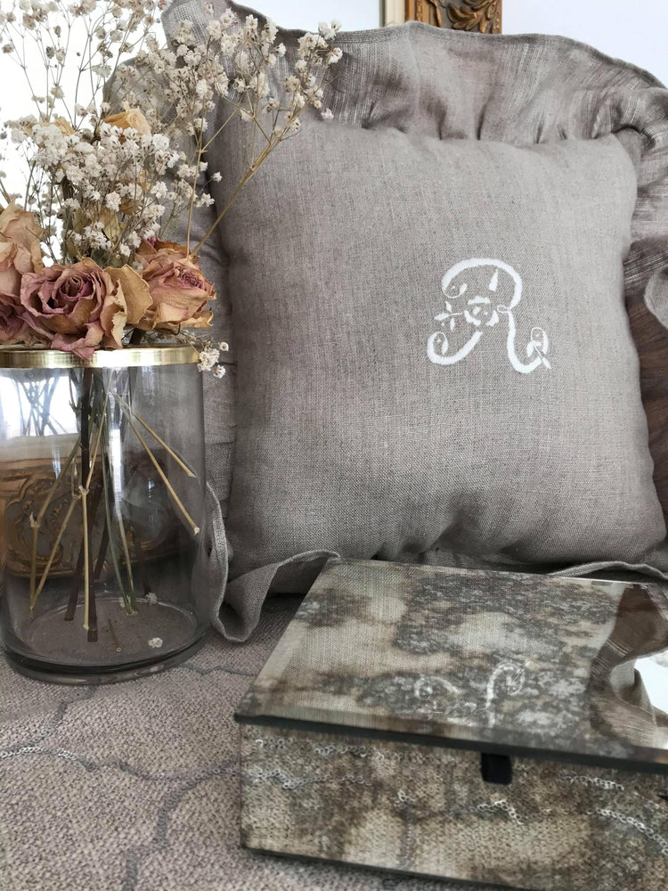 Coussin lin monogramme et broderie blanche, à volants